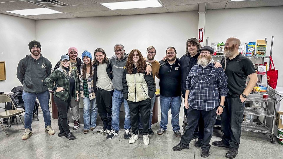 Cast and crew pose together indoors.