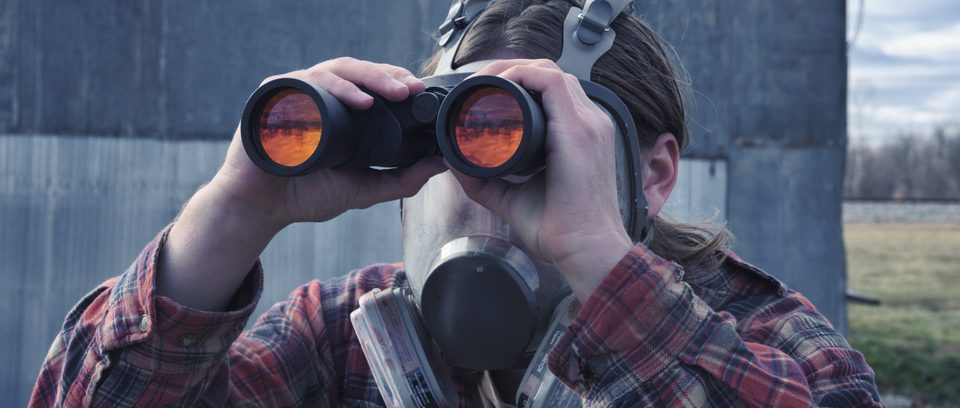 A character scans the horizon through binoculars.
