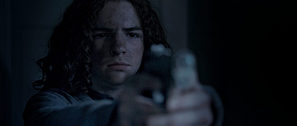 Samuel, played by Deacon Grasty, raising a handgun.