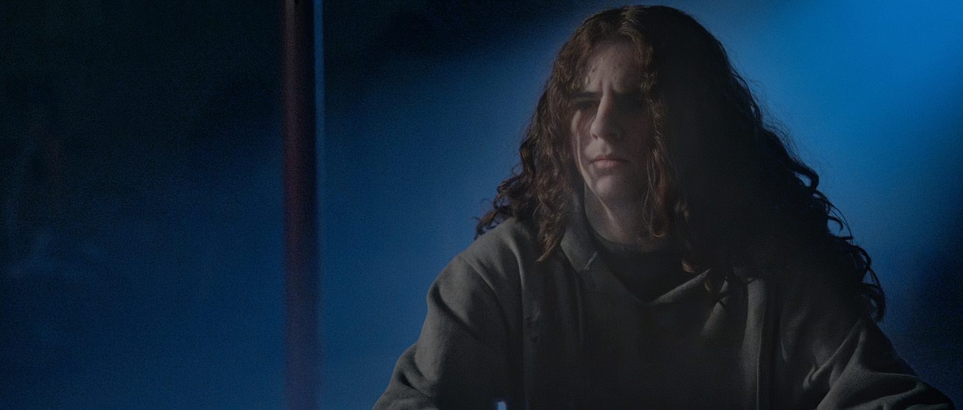 Samuel, played by Deacon Grasty, lit in cold blue light.